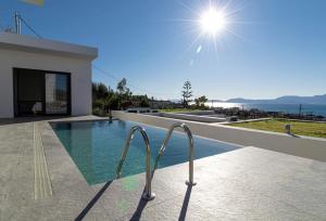 a house with a swimming pool with a view of the ocean at Villa Pale Rosa in Paleros