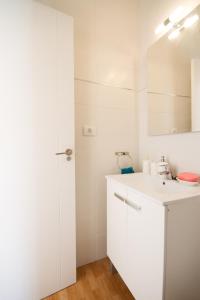 Un baño blanco con lavabo y espejo. en Luxury Europe, en Puerto de Mogán 50 fotos más