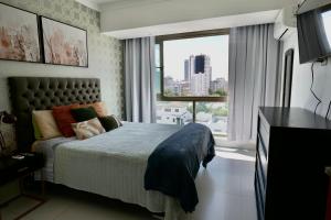 a bedroom with a bed and a large window at Arpel 6 SantoDomingo CItySeaView in Santo Domingo +48 photos