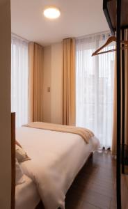 ein Schlafzimmer mit einem großen weißen Bett vor einem Fenster in der Unterkunft Qasamarca Hotel Boutique in Cajamarca