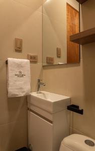 ein Badezimmer mit Waschbecken, Toilette und Spiegel in der Unterkunft Qasamarca Hotel Boutique in Cajamarca + 67 Fotos