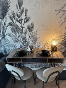 a dining table with two chairs in a room at Apartament Centro 9 in Leszno