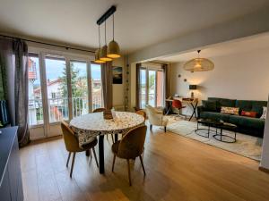 a living room with a table and chairs at Le sublime in Le Coteau