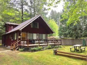 una pequeña casa roja con una mesa de picnic delante de ella en Papa`s Packwood Cabin, en Packwood