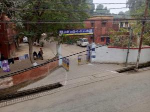 una strada con una recinzione e un cartello stradale di Srivastava House a Prayagraj