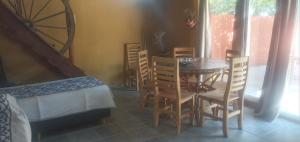a room with a table and chairs and a bed at Inti Mayu in Villa Cura Brochero