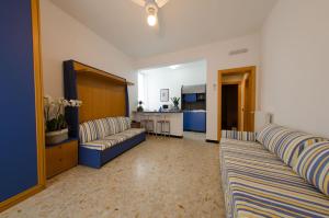 a hotel room with a bed, couch and a television at Residenza Adelaide in Finale Ligure