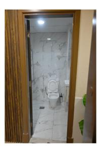 a bathroom with a toilet and a marble wall at Ajman Pearl Tawer Block B4-807 in Ajman  +14 photos