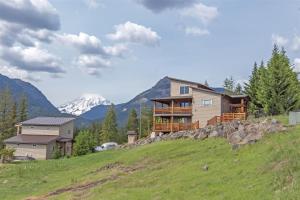a house on a hill with mountains in the background at Ravenwood in Packwood