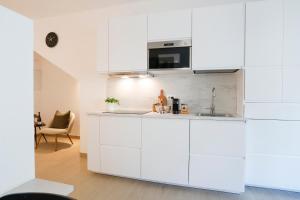 a white kitchen with a sink and a microwave at Junior Suite con spa privata disponibile su richiesta in Maso