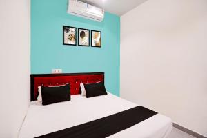 ein Schlafzimmer mit einem Bett mit einer blauen Wand in der Unterkunft HOTEL O S S STAY INN in Nagpur + 21 Fotos