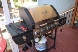 a bbq grill on a deck on a porch at Rustic Rapids · Wood Stove, Creek, Sauna in Packwood