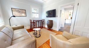 a living room with a couch and a table at Palm Paradise - Renovated 1891 Queen Anne - Historic DT Quarter Mi Stroll - Beach only 3 Mi in Saint Augustine