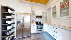 a kitchen with white cabinets and a stainless steel refrigerator at Palm Paradise - Renovated 1891 Queen Anne - Historic DT Quarter Mi Stroll - Beach only 3 Mi in Saint Augustine