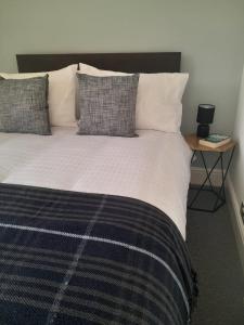 a bedroom with a large bed with pillows and a table at Doune 3 Outlander Apartment 1st floor in Stirling