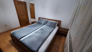 a bed with two blue pillows in a bedroom at Srce Cazina in Cazin
