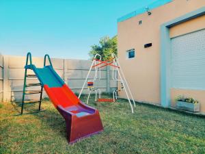 a playground with a slide in a yard at Sitios del Sol 1 in General Acha