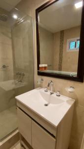 Un baño con lavabo, ducha y espejo. en Los Arboles de Frida, en Villa Icho Cruz