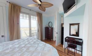 una camera da letto con un letto e un ventilatore a soffitto di The Chautauqua Gorgeous Direct OCEANFRONT Home 3 Decks Pool Table - Amazing Views a Saint Augustine Beach