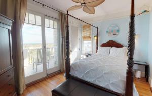 una camera da letto con letto a baldacchino e balcone di The Chautauqua Gorgeous Direct OCEANFRONT Home 3 Decks Pool Table - Amazing Views a Saint Augustine Beach