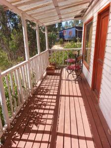 a porch with a table and a chair on it at cabañas campestre san juan 5 in San Juan +5 photos