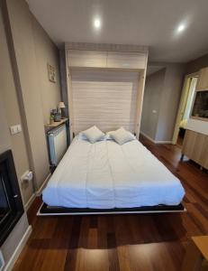 Una cama blanca grande en una habitación con televisión. en Las Margas Apartamento, en Sabiñánigo