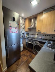 cocina con nevera y lavavajillas en Las Margas Apartamento, en Sabiñánigo