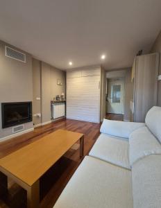 una sala de estar con un sofá y una mesa en Las Margas Apartamento, en Sabiñánigo
