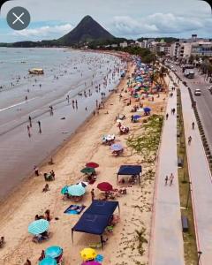 una spiaggia con un sacco di persone di Pousada e restaurante veredas a Piúma Altre 5 foto