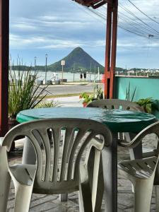 a table and chairs with a view of a mountain at Pousada e restaurante veredas in Piúma