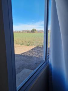einen Blick auf ein Feld aus einem Fenster in der Unterkunft Pasadena in Junín