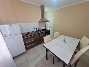 eine Küche mit einem Tisch und einem weißen Kühlschrank in der Unterkunft Pasadena in Junín + 4 Fotos