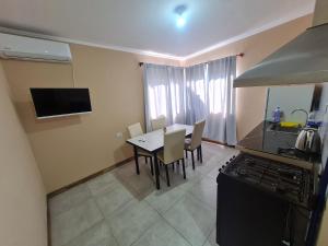 eine Küche und ein Esszimmer mit einem Tisch und einem Herd in der Unterkunft Pasadena in Junín