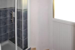 a shower with a glass door in a bathroom at Maison accueillante à Saint-Gènes-Champespe + Vue sur le lac in Saint-Genès-Champespe