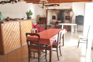 a dining room with a table and chairs in a kitchen at Maison accueillante à Saint-Gènes-Champespe + Vue sur le lac in Saint-Genès-Champespe