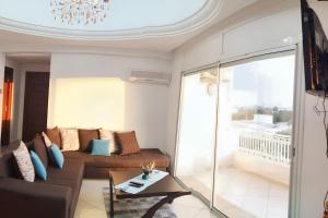 a living room with a couch and a balcony at Sea View Apartment in Hammamet with Shared Pool in Hammamet