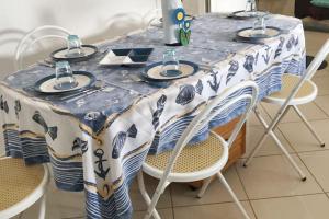 a table with chairs and a blue and white table cloth at Sea View Apartment in Hammamet with Shared Pool in Hammamet