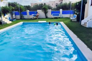 a swimming pool with blue water in a yard at Sea View Apartment in Hammamet with Shared Pool in Hammamet