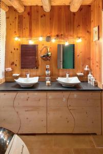 a bathroom with two sinks on a wooden wall at Maison chaleureuse à Mont >Vue montagne & cheminée in Mont