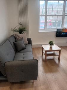 a living room with a couch and a table at Good Charming Apartment in London