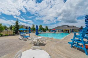 a swimming pool with chairs and blue chairs at The Monarch - 4 Butternut in Cherry Valley