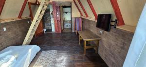 a room with a bed and a table and a tv at CabañasDoñaMaria in San Pedro La Laguna
