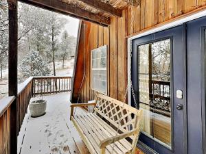 una veranda in legno con panchina nella parte anteriore di una cabina di Docs Den a Ruidoso
