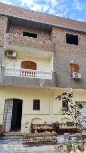 a large brick building with a balcony on the side at Rawan apartments in Luxor