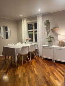 House with a beautiful seaview في ترومسو: غرفة طعام مع طاولة بيضاء وكراسي