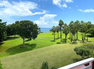 vista su un parco con palme e sull'oceano di Appartement, 2 chambres, Terrasse vue mer, très calme, Piscine premium, accès direct aux plages, restaurants, Village Vacances a Sainte-Luce