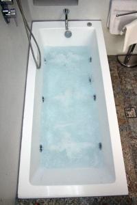 a white bath tub in a bathroom at Superior Apartment Near Beach in Chania