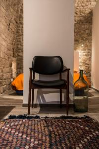 czarne krzesło siedzące w pokoju z butelką w obiekcie Residenza La Corte Assisi w Asyżu