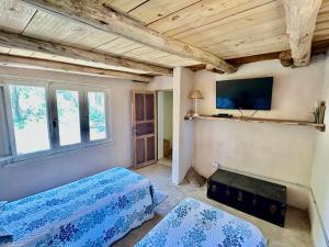 une chambre avec deux lits et une télévision au mur dans l'établissement 2 Casas de Campo con bajada exclusiva al Rio Pinto en la Naturaleza, à Cuchi Corral