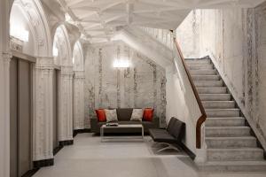 a living room with a couch and a staircase at The Godfrey Hotel Boston in Boston